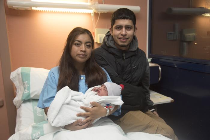 Los padres del primer bebé oscense posan con el pequeño.