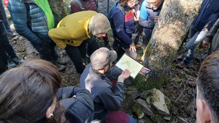 Uno de los investigadores explica a los asistentes algunas de las mediciones que se están realizando en el abetal Fuente del Paco de Villanúa.