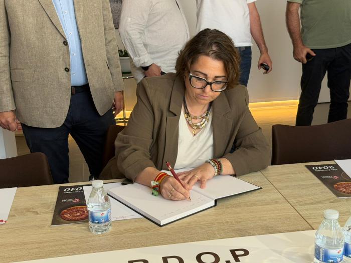 La consejera de Agricultura, Ganadería y Alimentación, Arancha Simón, ha firmado en el libro de honor del Consejo Regulador de la DOP Jamón yPaleta de Teruel.