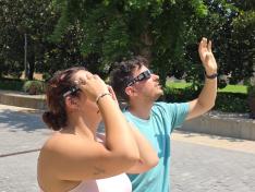 Dos jóvenes prueban el material que se deberá utilizar para ver el eclipse.
