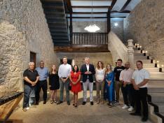 Foto de familia de la visita institucional a la hospedería de Allepuz, con el consejero Blasco en el centro.