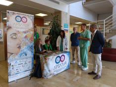 Profesionales médicos y miembros de las asociaciones APSATUR y AECC en la mesa informativa en el Servet