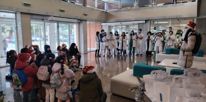 Alumnado del Colegio San José de Calasanz durante la entrega de adornos navideños en el hall del Hospital de Barbastro.