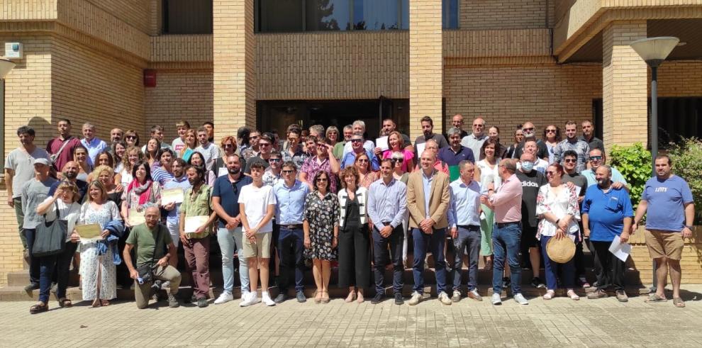 Foto de familia tras el acto de clausura de siete escuelas taller y talleres de empleo en Huesca