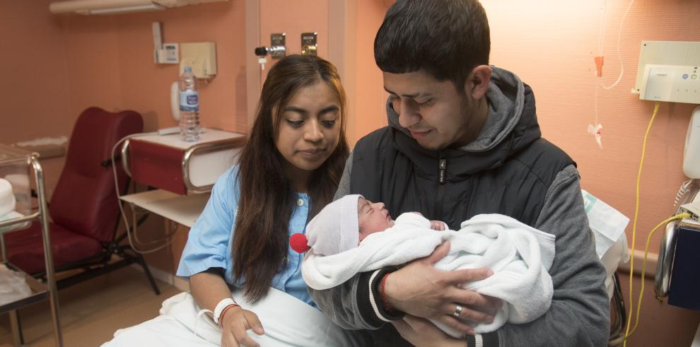 Los padres del primer bebé oscense posan con el pequeño.