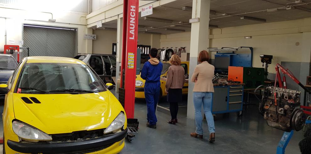 Uno de los alumnos enseña el taller de mecánica a Broto y Carbó