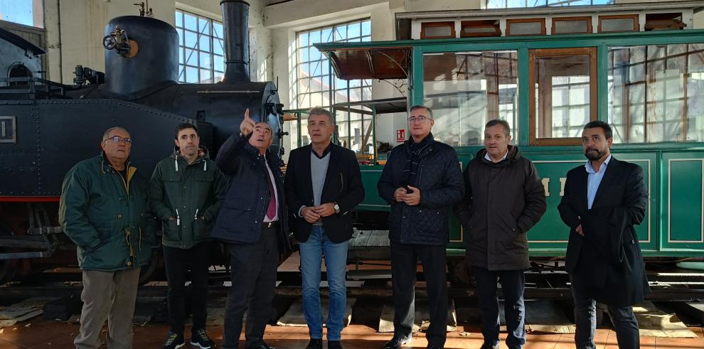 El consejero, junto al alcalde de Utrillas, frente a una de las locomotoras antiguas