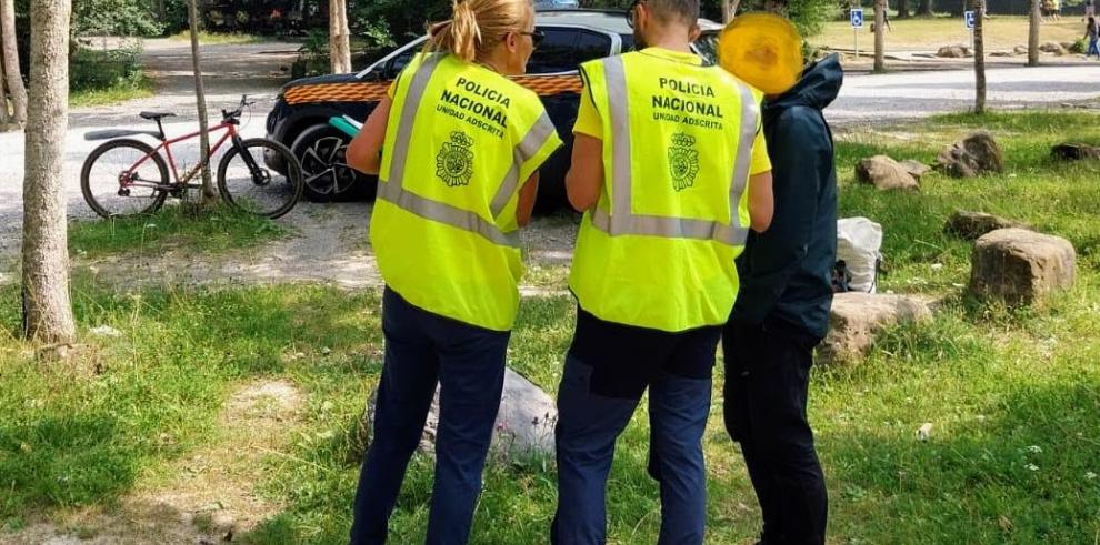 Dos agentes de la Policia Nacional adscrita informan a un visitante en la campa del Parque Nacional de Ordesa y Monte Perdido