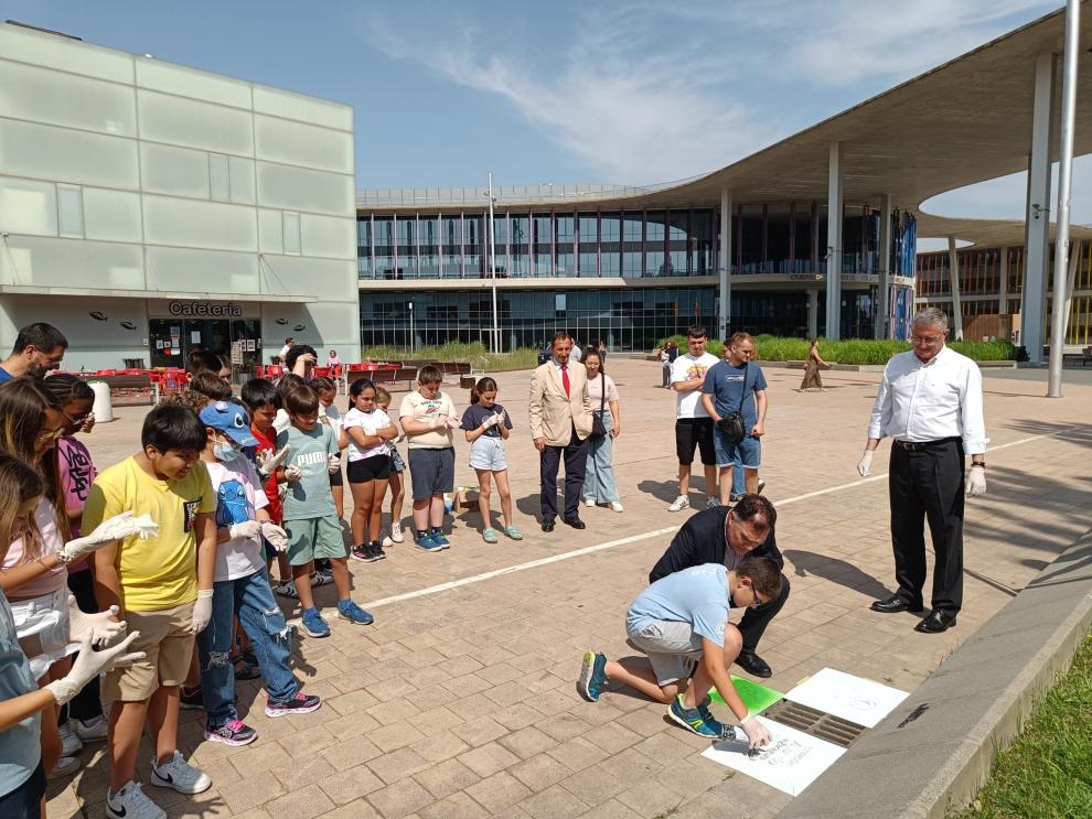 Blasco, junto al director del acuario y al grupo de escolares que han participado en la campaña.