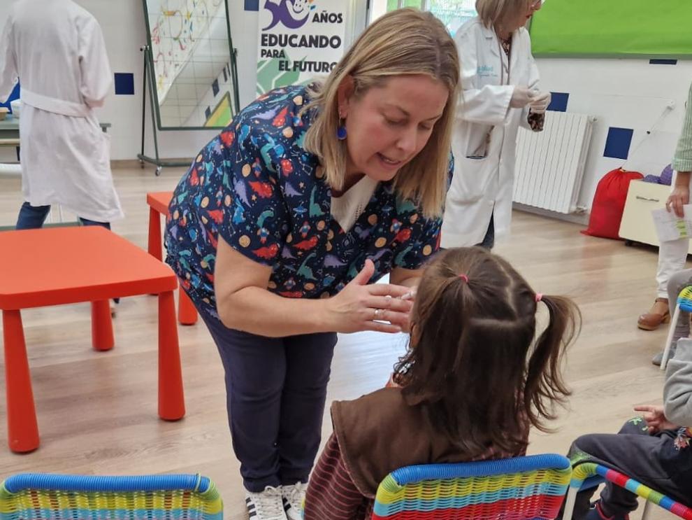La enfermera Isabel Monzón administra la vacuna a una de las pequeñas en el Colegio Guillermo Fatás, de Santa Isabel
