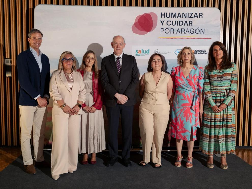 El consejero de Sanidad con las tres profesionales que reciben el reconocimiento a su trayectoria y otros representantes institucionales